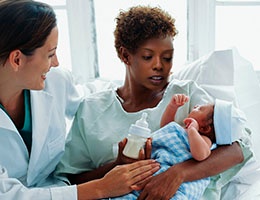 Blog_MaternalMortality5Strategies_BabyNewbornDepressedMotherHospitalHoldBottleDoctor_260x200px